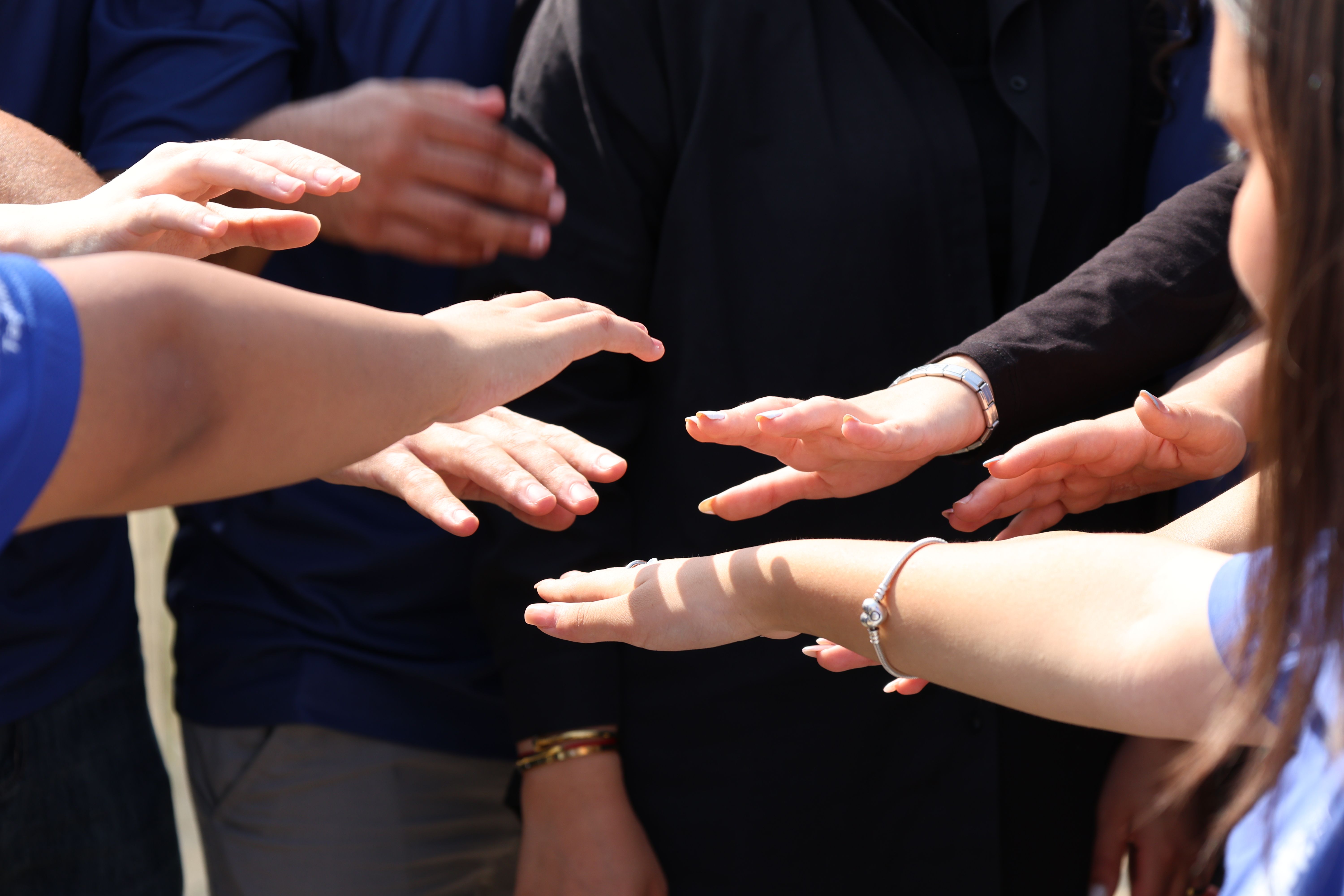 Diverse group of people placing hands together in unity, symbolizing plaintiffs joining a class action lawsuit