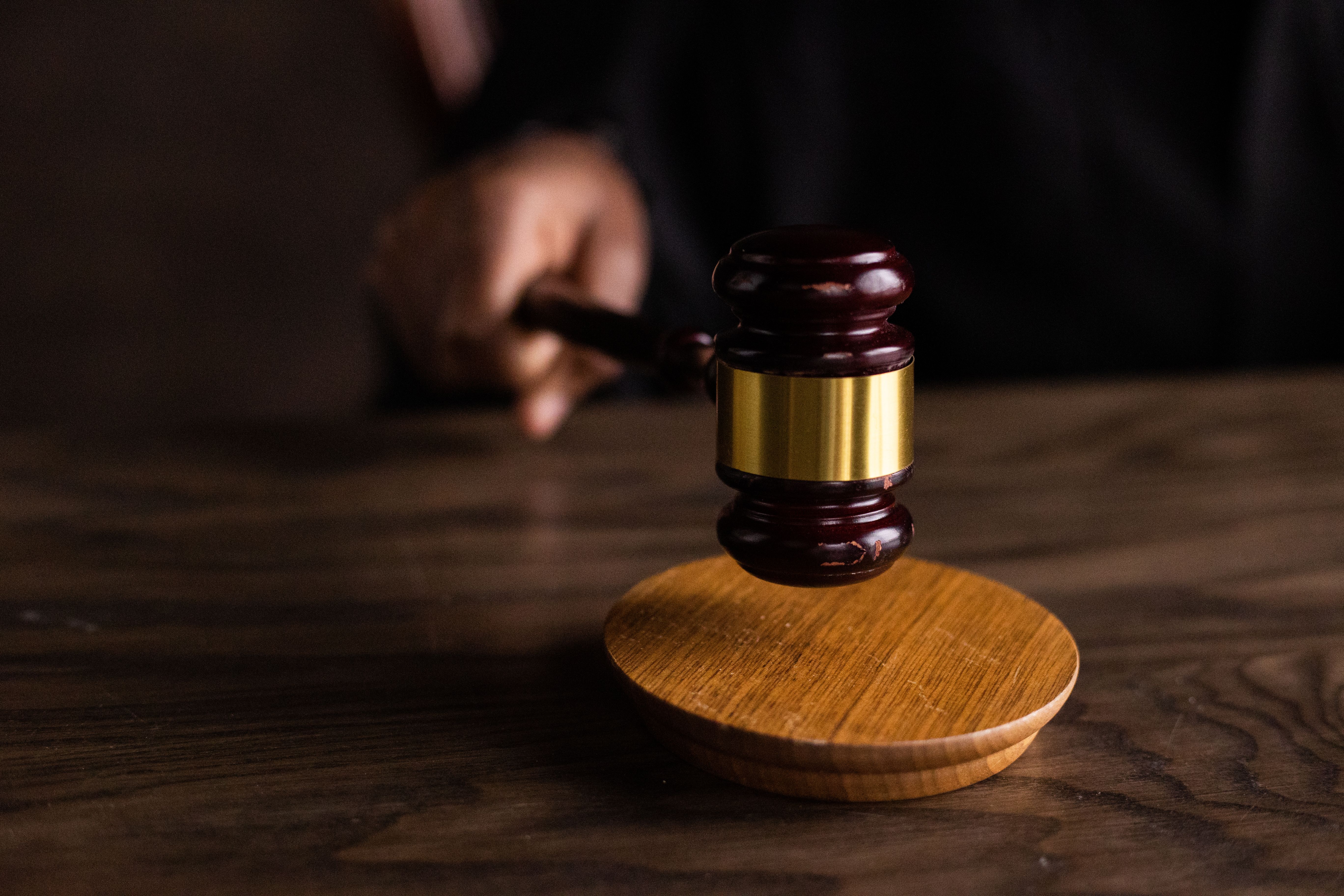 Wooden gavel striking a sound block in a courtroom, symbolizing court rulings in cross-border class actions