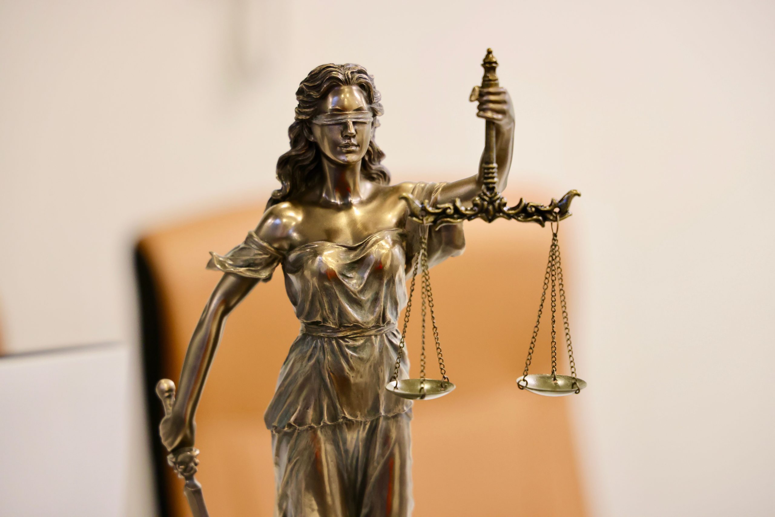 Close-up of the Lady Justice statue holding scales, symbolizing fairness in cross-border class action litigation